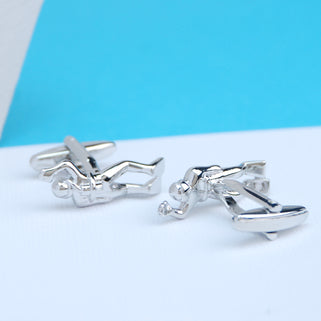 Silver divers cufflinks shown in close up shot on white and blue background