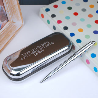 Silver chrome pen with matching case with "Thank you for being such a loving and caring brother" engraved in straight walk font shown close up on a desk