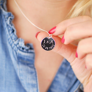 Sterling Silver Celebration Necklace. Silver round disc with "L&A 26.08.2022" engraved, shown in close up shot on model