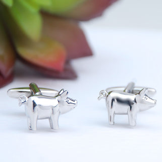 Silver pig cufflinks shown in close up shot