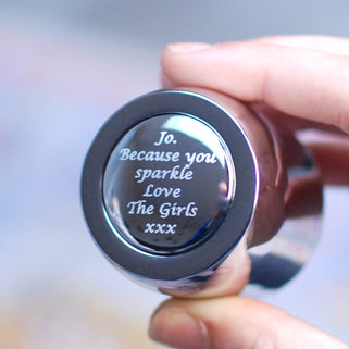 Silver Champagne Or Prosecco Bottle Stopper with "Jo. Because you sparkle Love The Girls xxx" message engraved shown in close up held by model