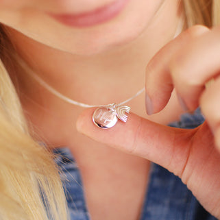 Sterling silver rainbow necklace with personalised circle disc engraved with "Hope" shown in close up shot on model.