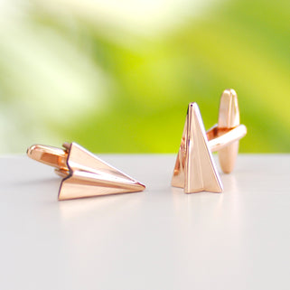 Rose gold coloured paper plane cufflinks shown in close up shot
