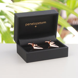 Rose gold coloured paper plane cufflinks shown in black Penelopetom cufflinks box
