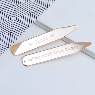 Rose gold collar stiffeners with "heart Simon heart" engraved on one and "Better stiff than floppy" engraved on the other, shown in close up shot.