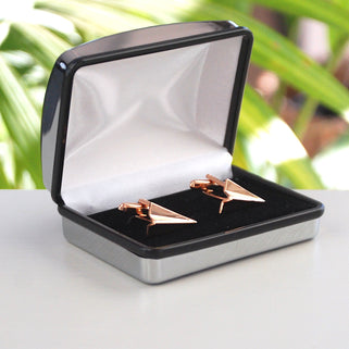Rose gold coloured paper plane cufflinks shown in silver rectangle chrome cufflinks box.
