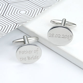 silver oval cufflinks with "Father of the bride" and "28.02.2019" engraved, shown in close up shot