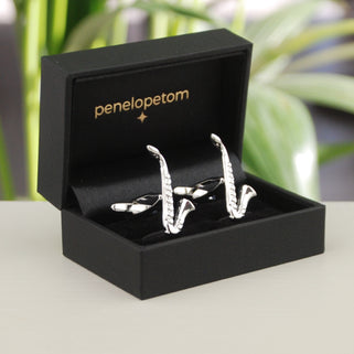 Silver saxophone cufflinks shown in black penelopetom cufflinks box