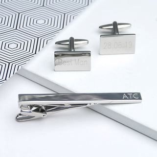 Silver cufflinks and tie clip set shown in close up shot.