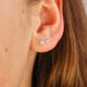 Sterling Silver Tiny Arrow Stud Earrings shown in close up shot on model