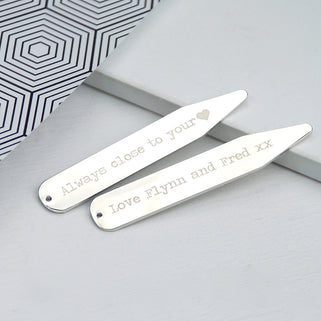 Silver collar stiffeners with "Always close to you heart" engraved on one and "Love Flynn and Fred" engraved on the other, shown in close up shot.