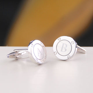 Silver porthole cufflinks with initial "A" on the left cufflink and "B" on the right cufflink, shown in close up shot