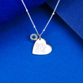Sterling Silver Heart Charm with personalised "Abi, Fab at 50" and Blue Topaz/December birthstone on satellite chain necklace, shown in close up shot