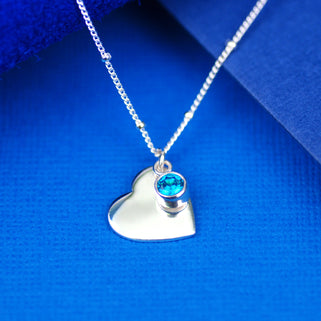 Sterling Silver Heart Charm and Blue Topaz/December birthstone charm on satellite chain necklace, shown in close up shot