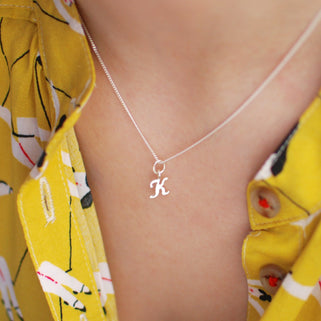 Sterling Silver Script Mini Initial   Letter "K" Necklace shown in close up shot on model.