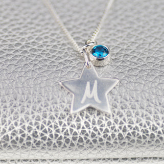 Silver Star with "M" Engraved and Blue Topaz/December birthstone charm Necklace shown in close up shot