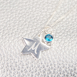 Silver Star with "M" Engraved and Blue Topaz/December birthstone charm Necklace shown in close up shot