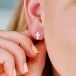 Sterling Silver Tiny Cross Stud Earrings shown on close up of model