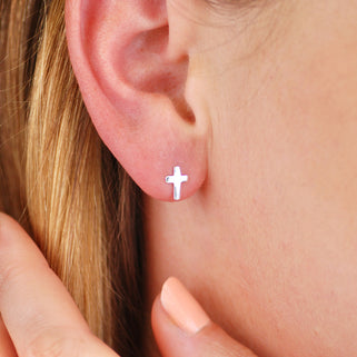 Sterling Silver Tiny Cross Stud Earrings shown on close up of model