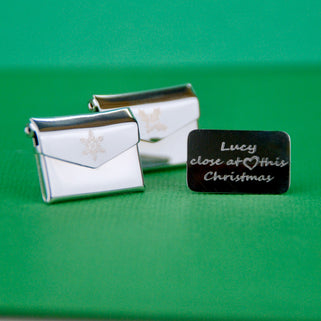 Christmas Card Message Pin with snowflake or Holly engraved on the front and letter with personalised engraved message "Lucy close heart this Christmas" shown in close up shot